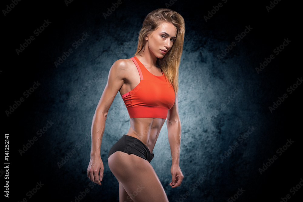 Muscular woman in studio on dark background Muscular woman in studio on dark background