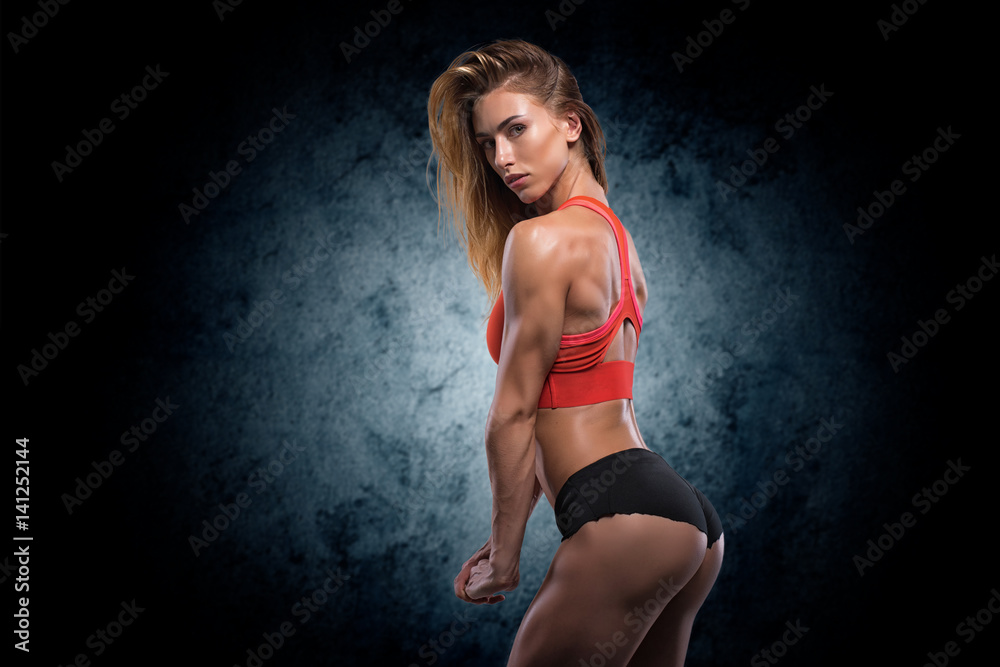 Fototapeta premium Muscular woman in studio on dark background