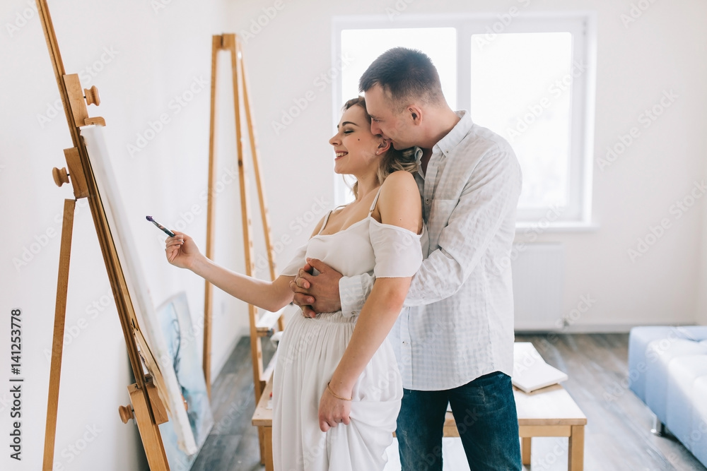 Happy couple flirting and painting picture.