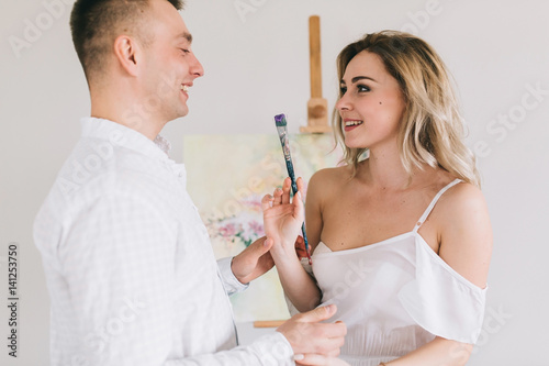 Happy couple flirting and painting picture.