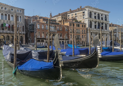 Parking point of traditional Venetian gondolas on the Grand Canal, in front of Palazzo Cavalli, on a sunny summer day, Venice, Italy