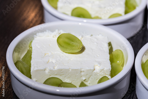 Tapeta White desert bowl with cheep's cheese and green grapes as dessert before grillin