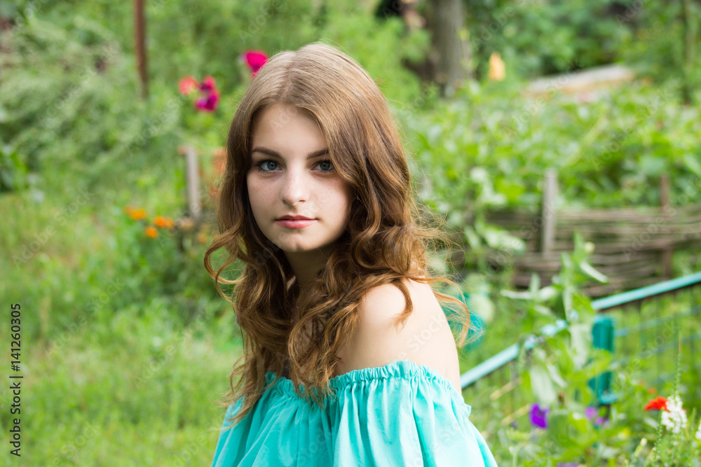 beautiful girl posing in the garden . the height of spring. a green garden a beautiful green background . a tender portrait beautiful girl posing in the garden . the height of spring. a green garden a beautiful green background . a tender portrait
