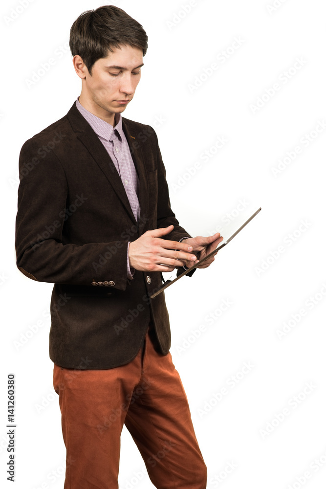 Cheerful young man businessman in suit working on digital tablet and smiling while standing isolated Cheerful young man businessman in suit working on digital tablet and smiling while standing isolated