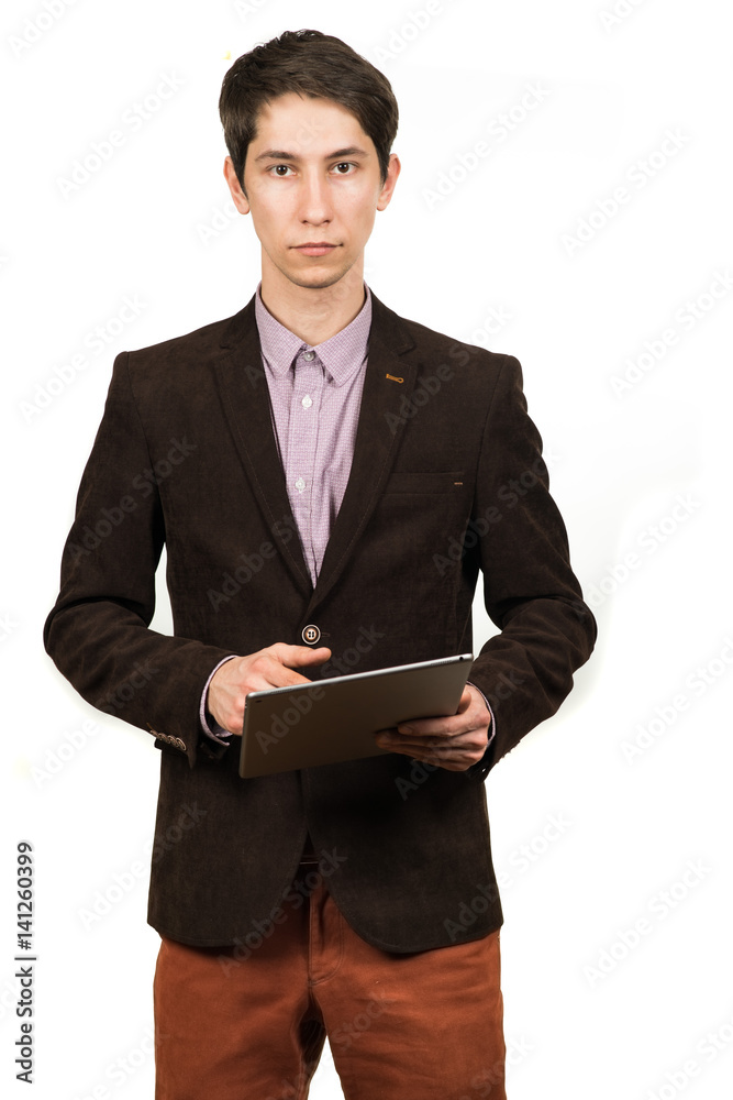 Cheerful young man businessman in suit working on digital tablet and smiling while standing isolated Cheerful young man businessman in suit working on digital tablet and smiling while standing isolated