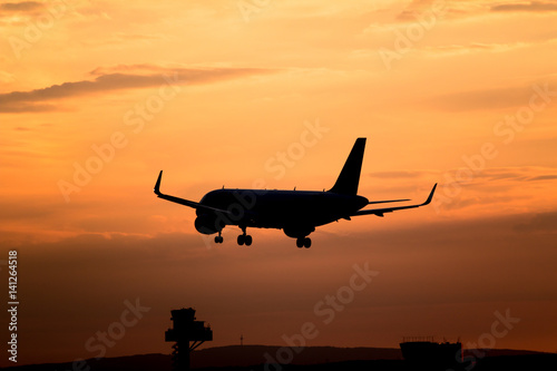 Airplane landing at sunset