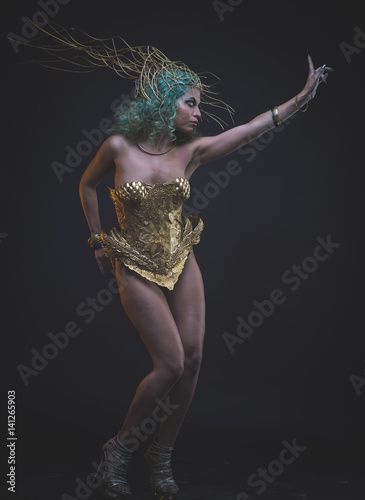 Virgin, Latin woman with green hair and gold tiara, wears a handmade warrior armor © Fernando Cortés