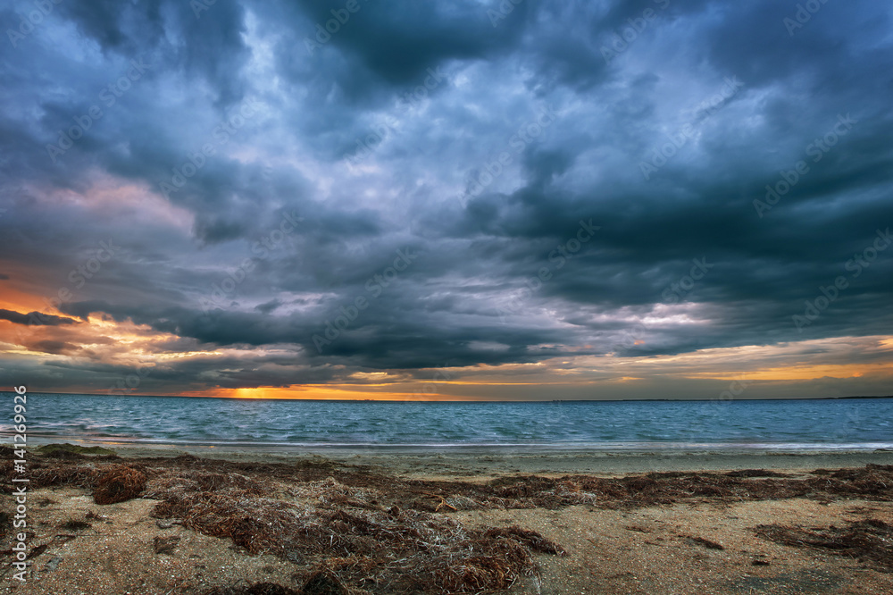 Fototapeta premium Gloomy clouds, sunset over the sea, storm