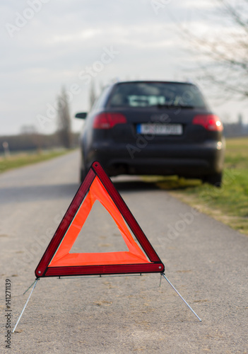 breakdown triangle stands near a broken car