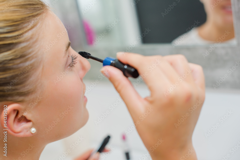 Woman applying mascara Woman applying mascara