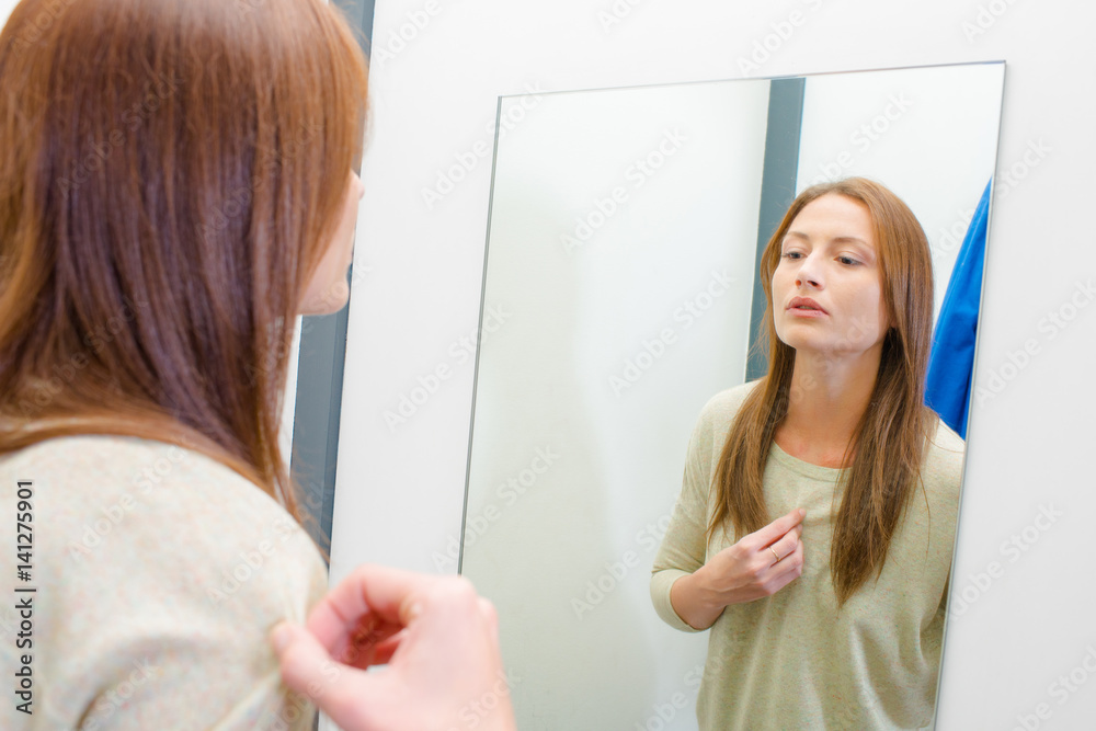 woman looking at herself in the mirror
