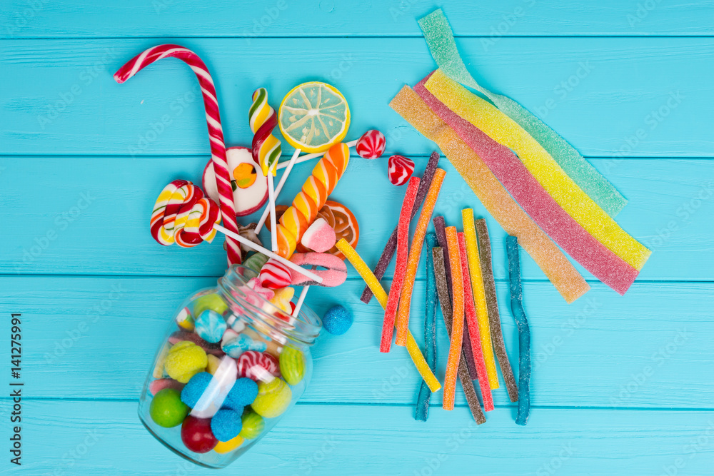 Cattered chewing and licorice sweets, lollipops and jelly candies from glass can