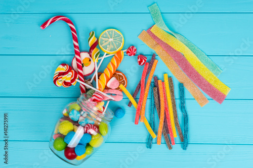 Obraz na płótnie Cattered chewing and licorice sweets, lollipops and jelly candies from glass can w salonie
