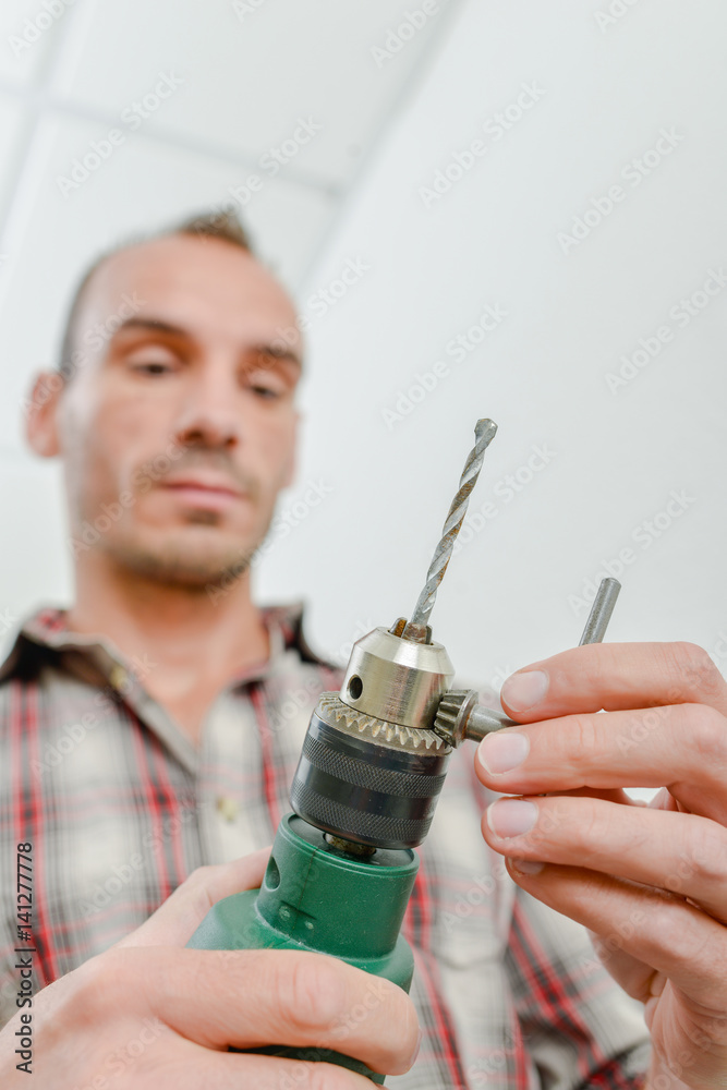 Naklejka premium Young worker using a drill