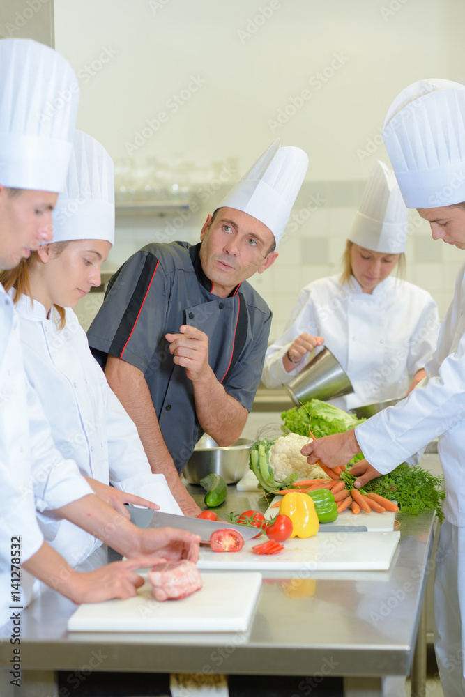 Chef instructing trainee caterers