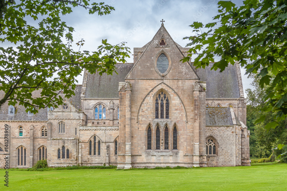 Pluscarden Abbey in Scotland with green grass and trees