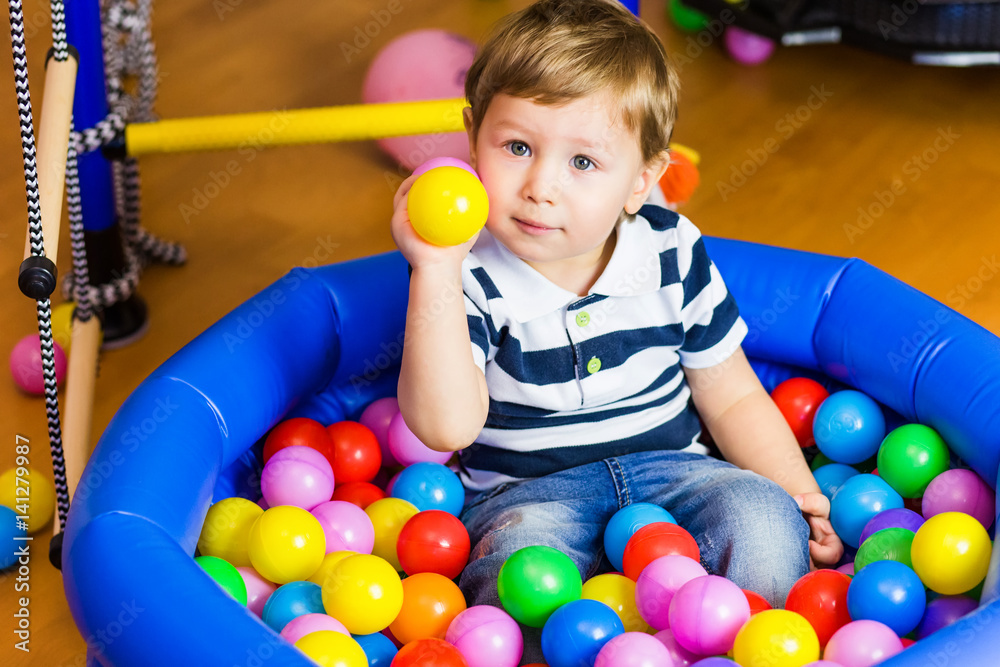 Obraz premium Little boy playing with balls