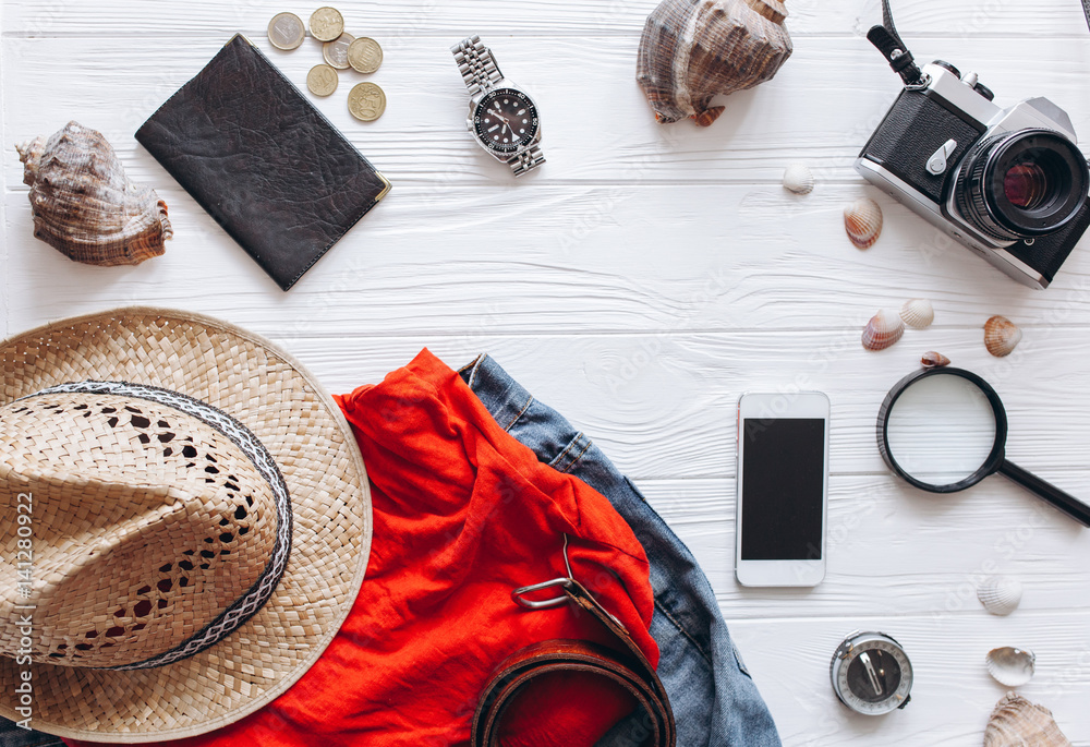 Top view of travel accessories set on white wooden background with copy space
