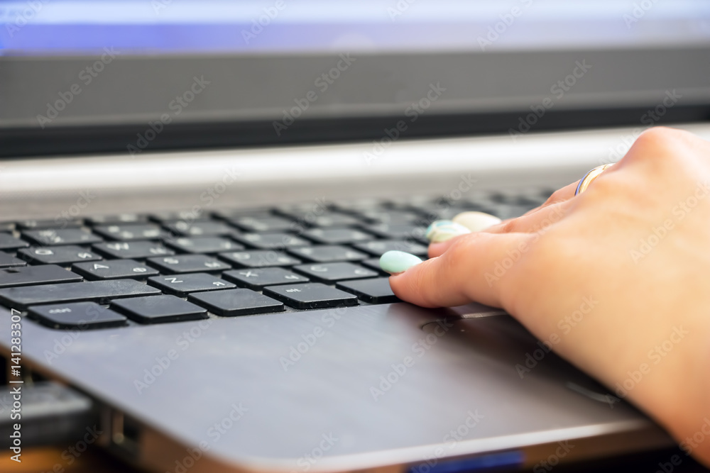 Woman's hand on laptop keyboard. Selective focus Woman's hand on laptop keyboard. Selective focus
