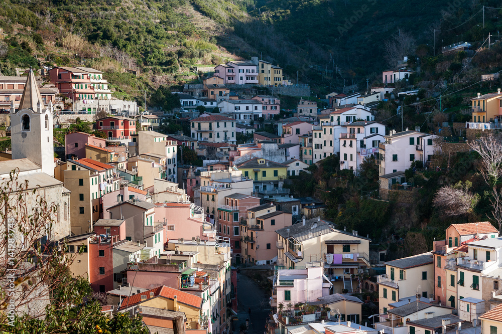 Village of Riomaggiore town with houses, located between mountains at Cinque Terre national park, Italy