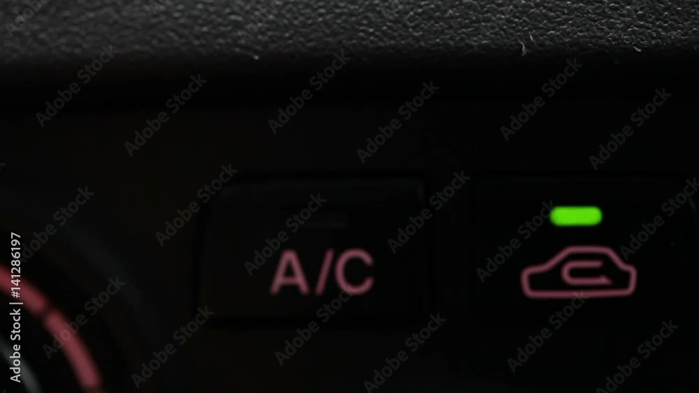 man turns on the air conditioning in the car. Close-up buttons man turns on the air conditioning in the car. Close-up buttons