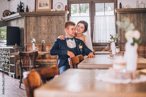 Cute married couple in cafe, bride kissing a groom . Pure tenderness