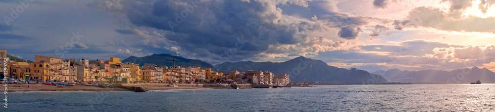 Colorful panoramic view of Sicily coastline with cloudy sunset sky