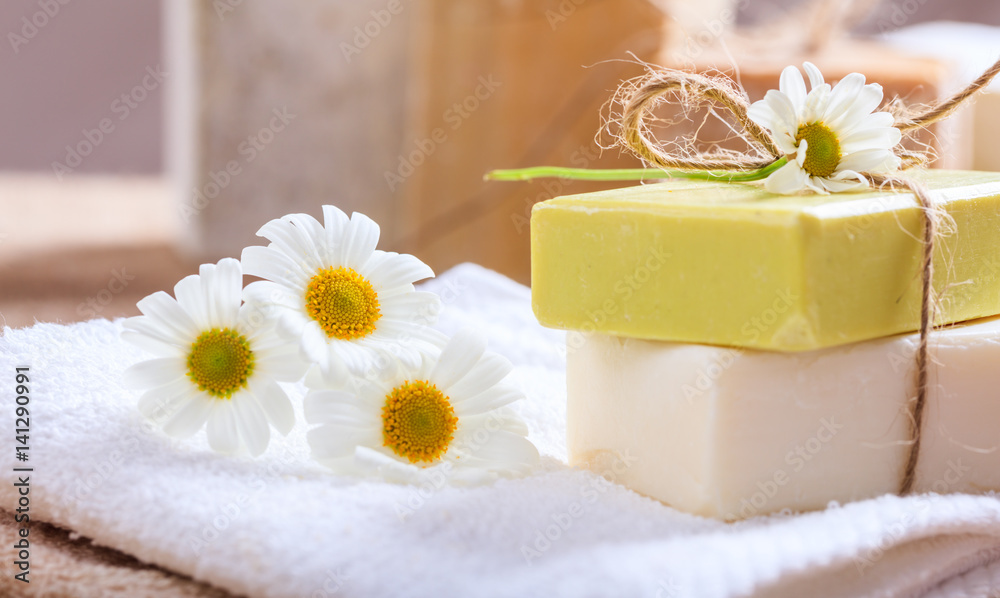 Handmade soap bars and chamomile on wooden background Handmade soap bars and chamomile on wooden background