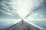 man walking between two seas