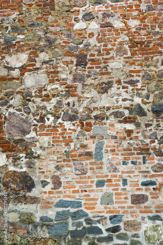 Old wall of medieval castle made of red bricks and stone