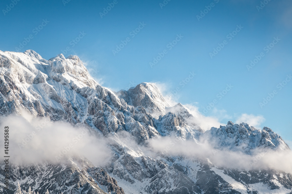 Snowcapped rocky mountain landscape with blue sky