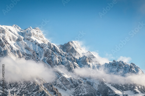 Snowcapped rocky mountain landscape with blue sky
