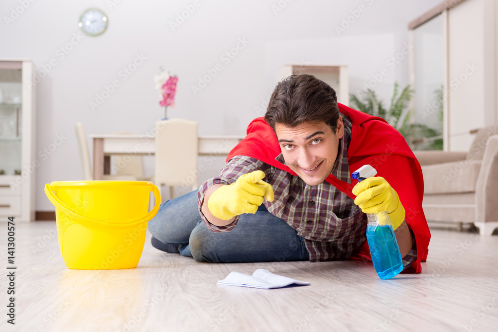 Naklejka premium Super hero husband cleaning floor at home