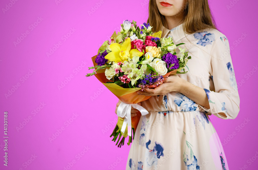 Beautiful girl in dress holding a bouquet of different flowers. Isolated