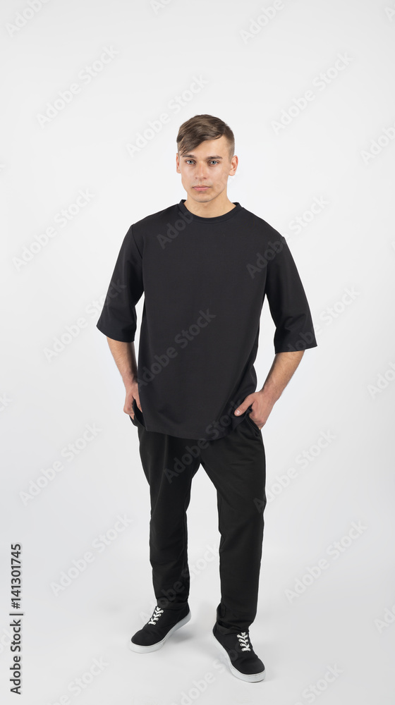 Young muscular man wearing black clothes and sneakers isolated on white background Young muscular man wearing black clothes and sneakers isolated on white background