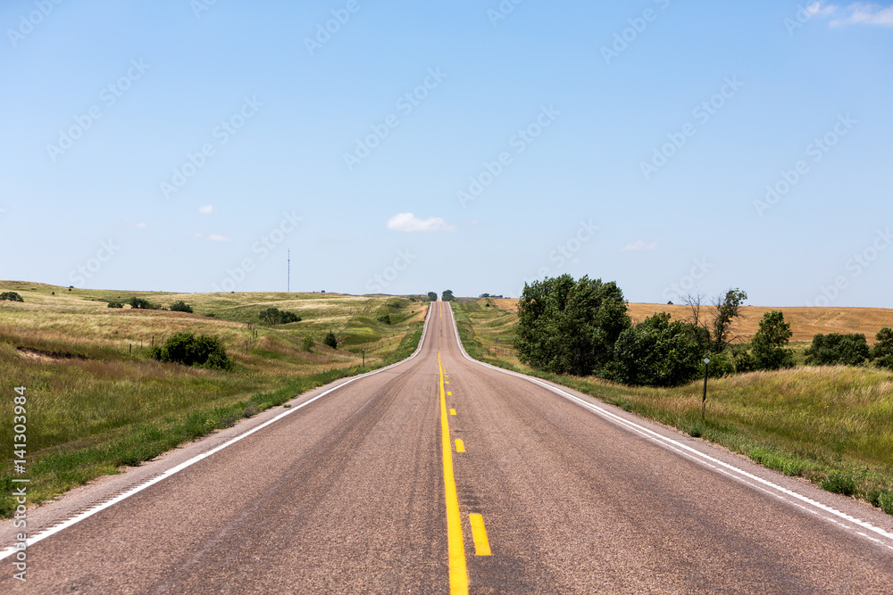 A road cutting through northern Nebraska on a summer day.
