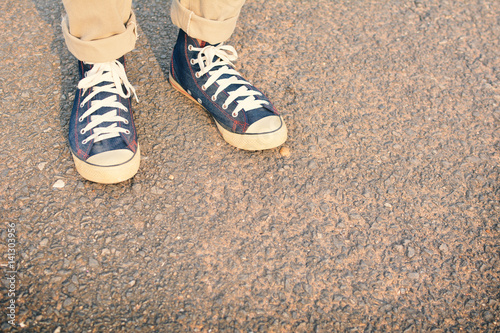 Hipster feet a man and jeans sneaker in nature and relax time on holiday. selective and soft focus color of vintage tone