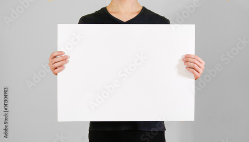 Man showing blank white big A2 paper. Leaflet presentation. Pamphlet hold  hands. Man show clear offset paper. Sheet template. Booklet design sheet  display read first person. Stock Photo