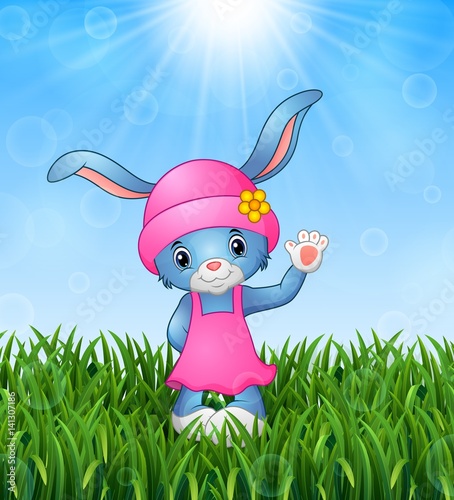 Cute rabbit cartoon waving in the grass on a background of bright sunshine