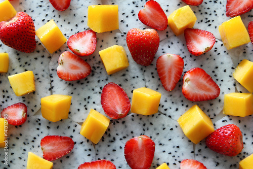 Ripe and fresh mango, dragon fruit and strawberries close up.