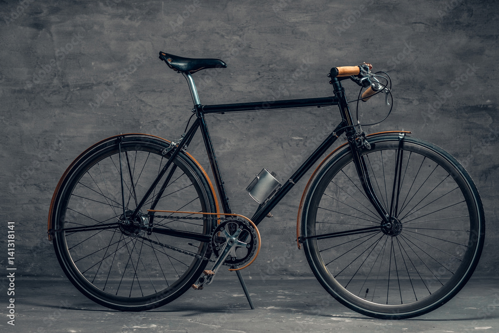 An authentic vintage single speed bicycle over grey background.