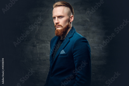 Redhead bearded hipster male dressed in a blue jacket.