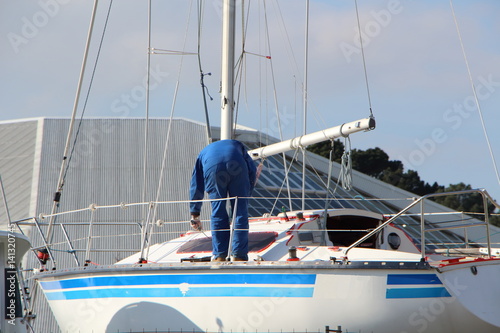 Ouvrier peignant un bateau 