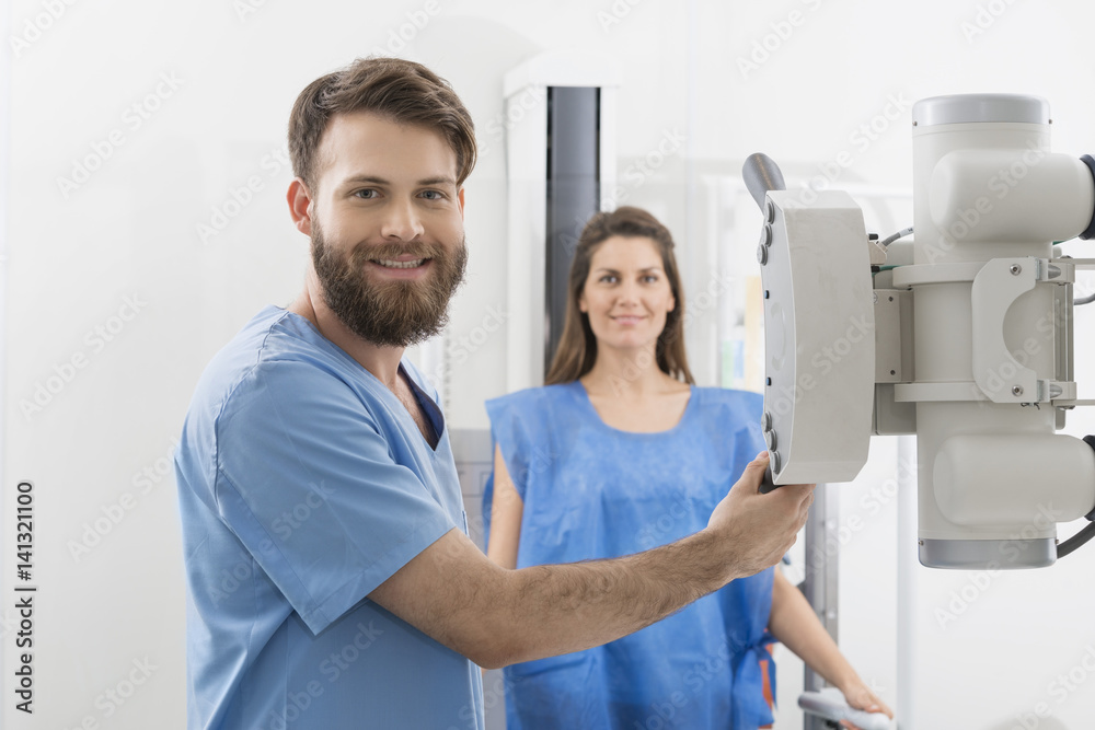 Fototapeta premium Radiologist Adjusting X-ray Machine Over Female Patient In Hospi