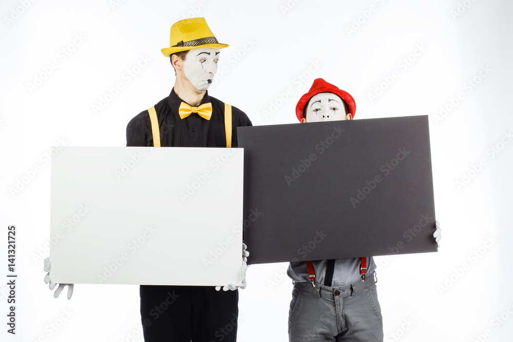 Two funny mimes holding a white blank on a white background. Two funny mimes holding a white blank on a white background.