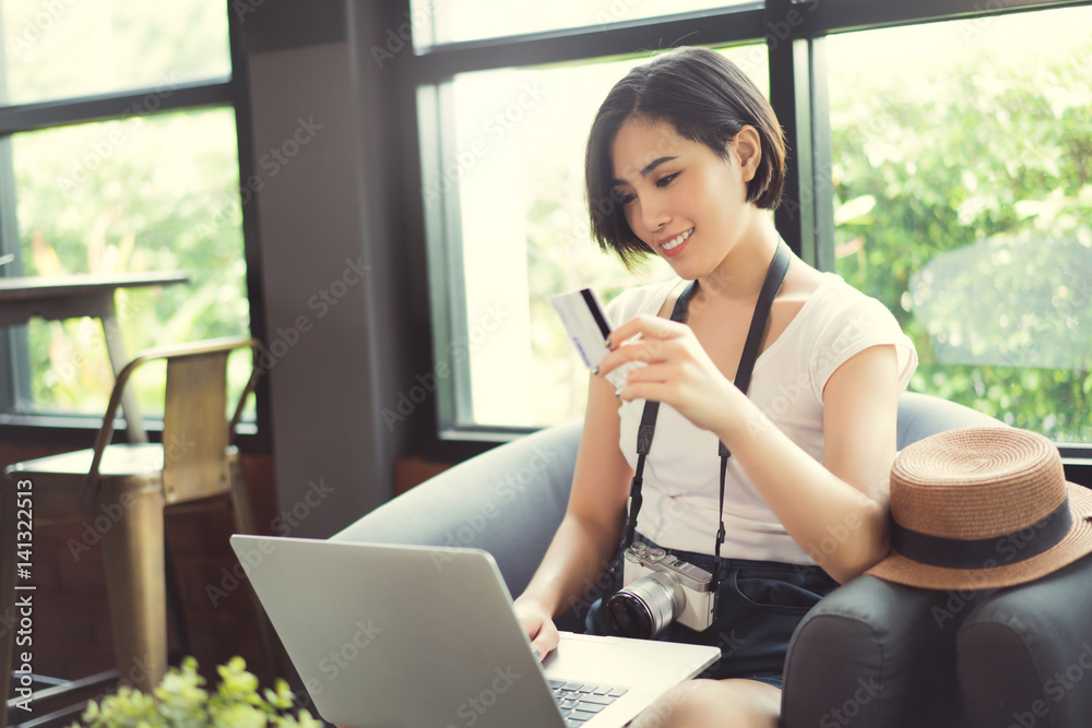 Woman asian travelers she shopping online or in flight. by credit card at a coffee shop.. Woman asian travelers she shopping online or in flight. by credit card at a coffee shop..