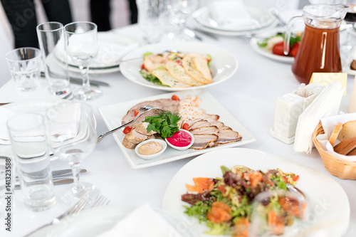 Restaurant table with food. Tasty appetizers, salads. Different meals for the guests on the wedding table