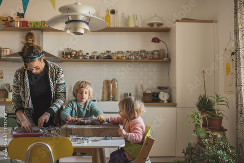 bambine e madre preparano biscotti in cucina photo