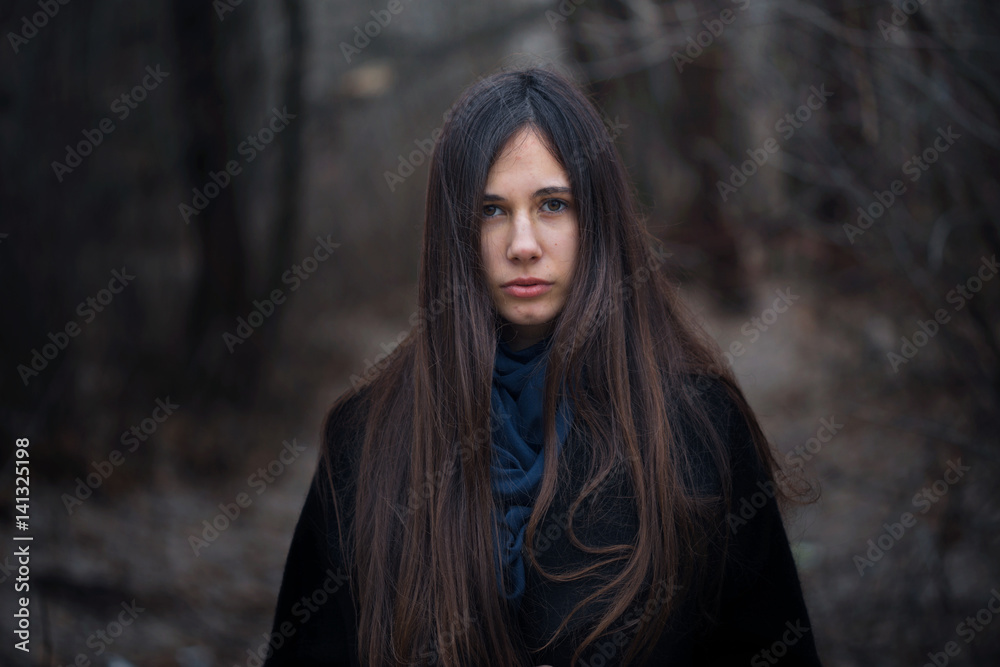 Naklejka premium Portrait of a beautiful girl in a dark forest
