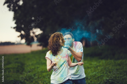 Young couple playing with coloured paint powder on the Holi Festival